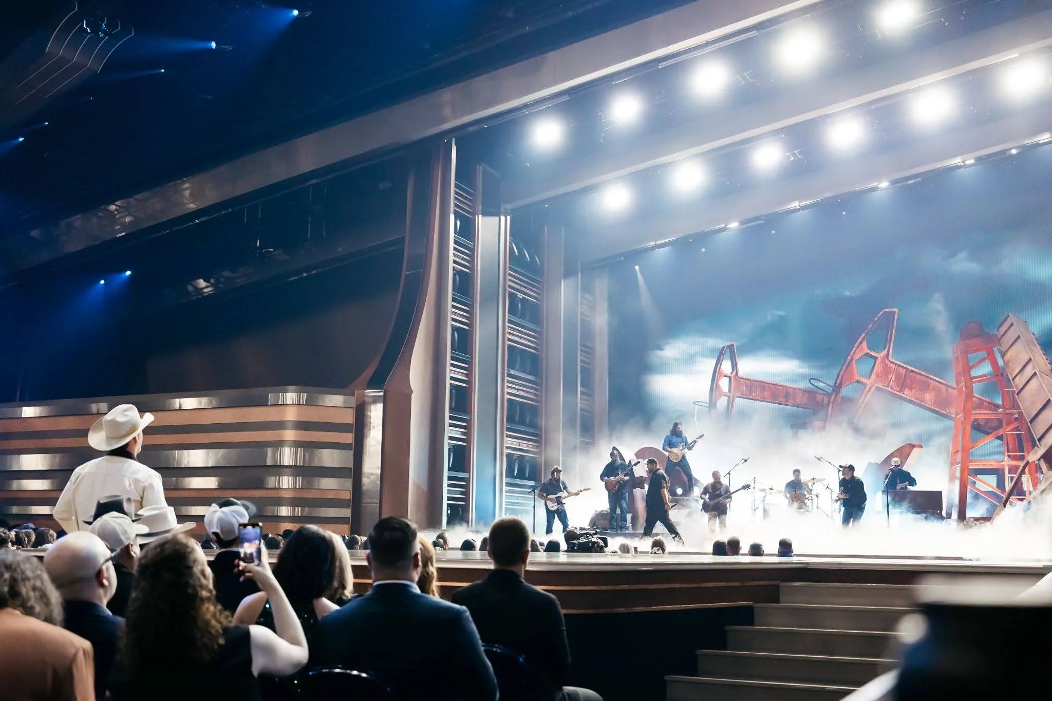 Stage performance with musicians and audience in a theater setting